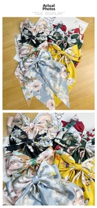 Close-up of vintage floral satin bow hair clips with long streamers on a wooden table
