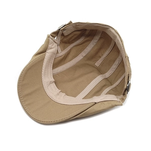 Inside view of khaki newsboy cap showing reinforced stitching and adjustable metal buckle