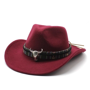 Detail of burgundy felt cowboy hat with ethnic band and silver bull skull ornament