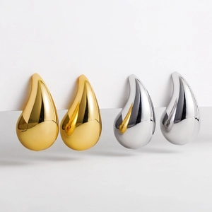 Polished 18K gold and silver stainless steel water drop earrings set on a white platform