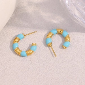 Detail of gold C-shape stud earrings with blue enamel stripes in a vintage style