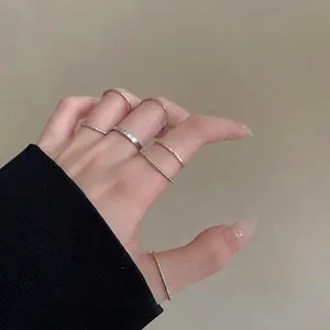 Set of silver minimalist rings in various textures worn by a model in a trendy style