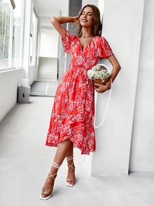 Détail d'une robe rouge à fleurs avec col en V et taille cintrée sur un mannequin
