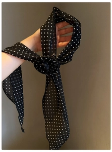 Detailed view of vintage black and white polka dot chiffon flower scarf necklace.