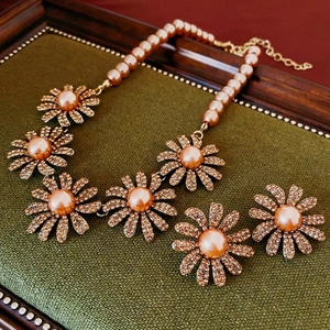 Detailed close-up of vintage daisy jewelry set with champagne pearls and crystals