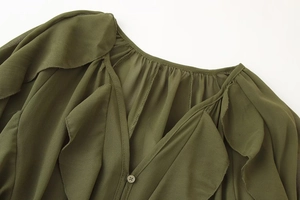 Detail van olijfgroene chiffon blouse met v-hals met ruches en de textuur van de knoopkraag