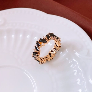 Macro shot of vintage gold ring with black stones and white zircons on porcelain
