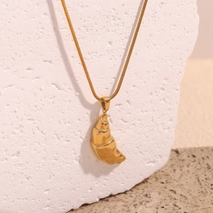Polished 18K gold croissant pendant necklace with sleek snake chain on stone base