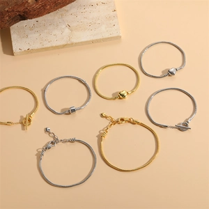Assorted gold and silver snake chain bracelets with heart charms and OT buckle closure