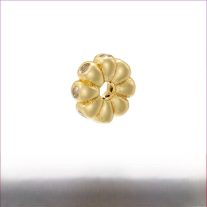 Macro detail of 18K gold plated brass petal bead spacer with clear zircon inlay