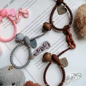 Close-up of wavy elastic hair ties with metal bells, heart charms, and plush puppy charms