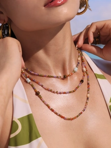 Detail of bohemian multilayer necklace with colorful gemstone beads on female model