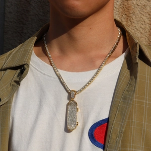 Detail of hip hop gold scooter pendant with clear rhinestones on cuban link chain
