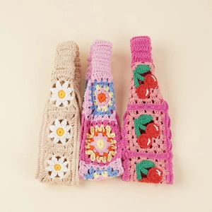 Detailed view of handmade crochet headbands with daisy, floral, and cherry knit patterns