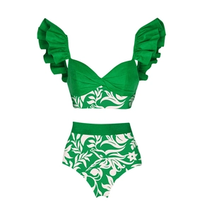 Flat lay of green ruffle bikini set with white floral prints and high-waisted bottom
