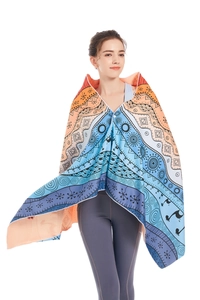 Detail of bohemian microfiber beach towel with vibrant orange and blue mandala patterns