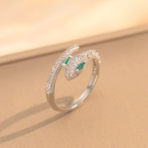 Silver snake open ring with green zircon eyes and crystal pavé on a silk background