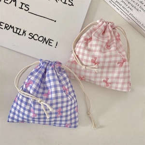 Close-up of pink and purple plaid drawstring bags with bow prints and cotton fabric detail
