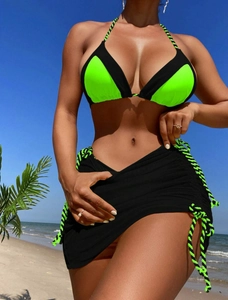 Detail of neon green and black bikini with side drawstring skirt on beach