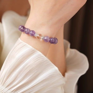 Detail of amethyst beaded bracelet with crystal charm and silver spacers on model wrist