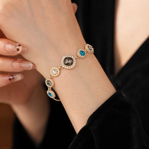 Detail of a luxury gold bracelet featuring colorful round crystals and micro-pavé diamonds
