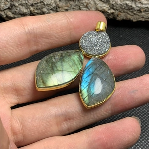 Detail of leaf-shaped labradorite pendants with blue flash and gold-plated metal edges