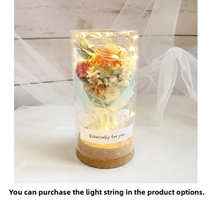 Detail of mini dried flower bouquet in glass jar with warm LED fairy lights and cork base