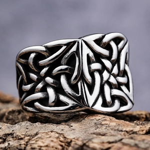 Vintage Celtic knot band ring in silver finish displayed on natural tree bark background