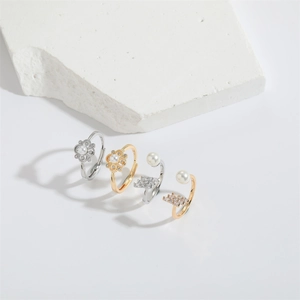 Floral and geometric open rings with pearls and diamonds on a white stone base
