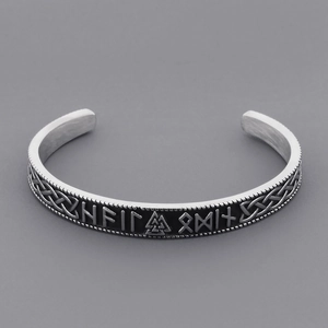 Macro shot of Viking Valknut symbols and Nordic Runes on a stainless steel cuff bracelet