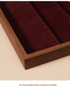 Close-up of walnut wood jewelry tray with deep red velvet lining and fine finish