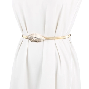Ceinture élastique dorée avec boucle feuille en strass sur une robe blanche