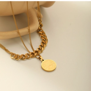 Macro shot of 18k gold plated double-layer necklace with coin pendant and Cuban link chain