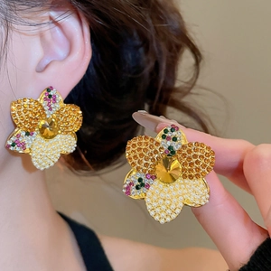 Close-up of elegant flower stud earring with yellow crystal and amber pave petals