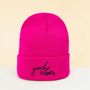Close-up of black 'good vibes' embroidery on a rose red ribbed knit beanie hat