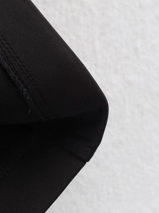 Macro shot of black fabric texture and professional stitching on dress hemline