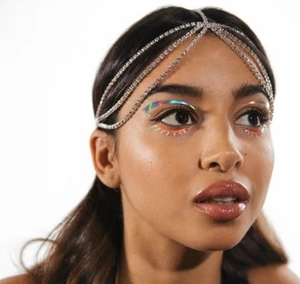 Macro detail of bohemian silver rhinestone multi-layer forehead chain and tassel headband
