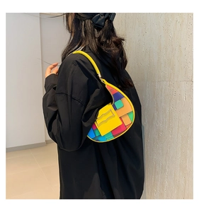 Fashionable woven crescent bag styled as an underarm shoulder bag on a model