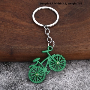 Macro detail of a bright green bicycle keychain with silver metal and crystal accents