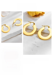 Detailed view of wide flat gold hoop earrings with polished finish and latch back closure