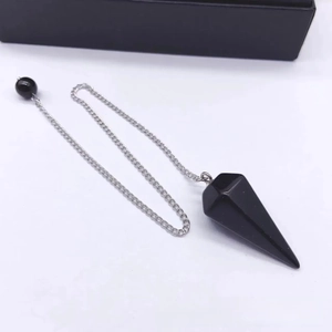 Black hexagonal crystal pendulum necklace with silver metal chain on white background