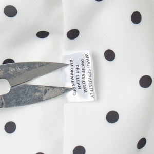 Vue détaillée du tissu à pois et étiquette d'entretien avec instructions de lavage du set