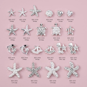 Detailed grid of silver starfish and seashell nail charms with pearls and rhinestones