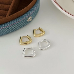 Polished silver and gold geometric triangular hoop earrings on white background