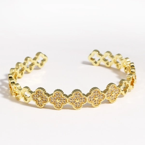 Détail du bracelet jonc en titane doré orné de trèfles sertis de cristaux et de découpes