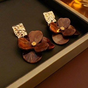 Details von Vintage-Acryl-Blumenohrringen mit goldenem Metall und braunen Blüten