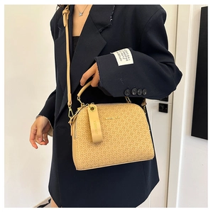 Chic light brown woven crossbody bag with JIAONIKA logo shown on a fashion model suit
