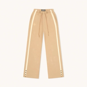 Détail du jogging large kaki avec bandes blanches et boutons-pression réglables aux pieds