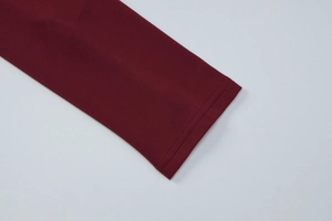 Gros plan détaillé des manches en tricot rouge foncé avec dentelle et texture fine