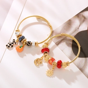 Verstellbare goldene Charm-Armbänder mit Sonnen-, Mond- und Kürbisanhängern auf Weiß